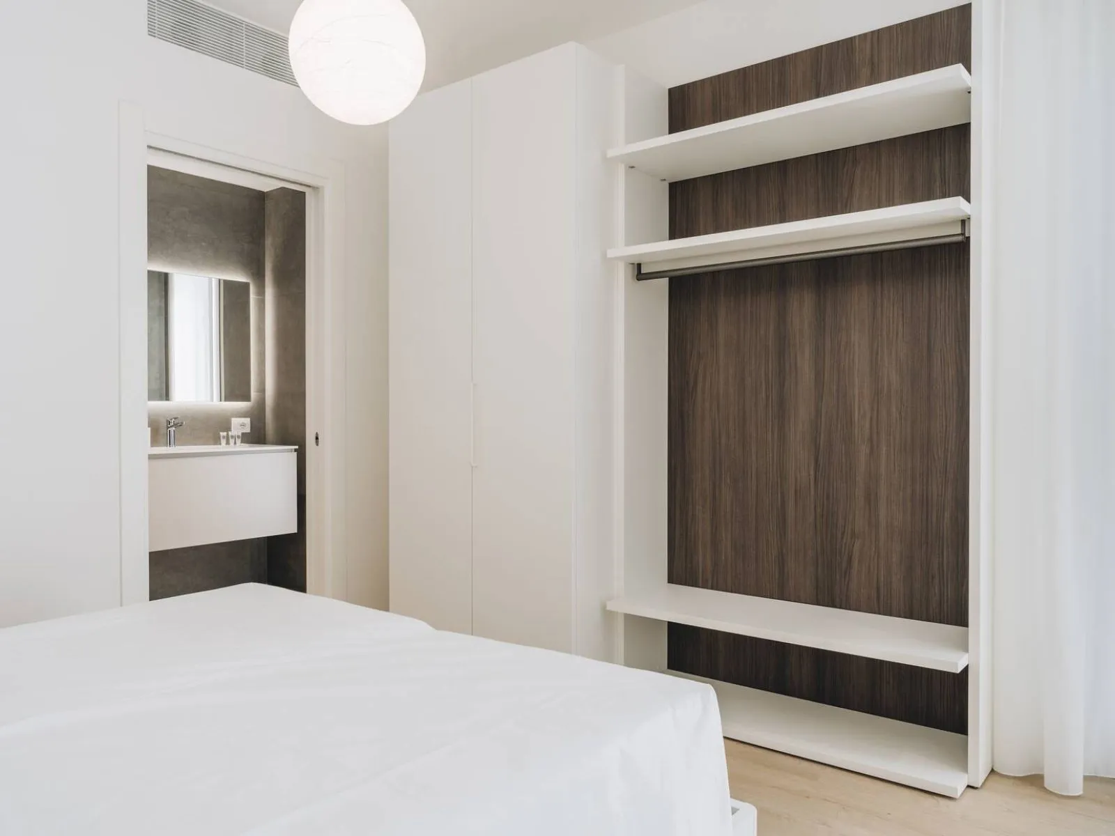 Armadio a muro con modulo aperto in legno scuro e accesso al bagno – appartamento T-05 Ca' Sette Treviso