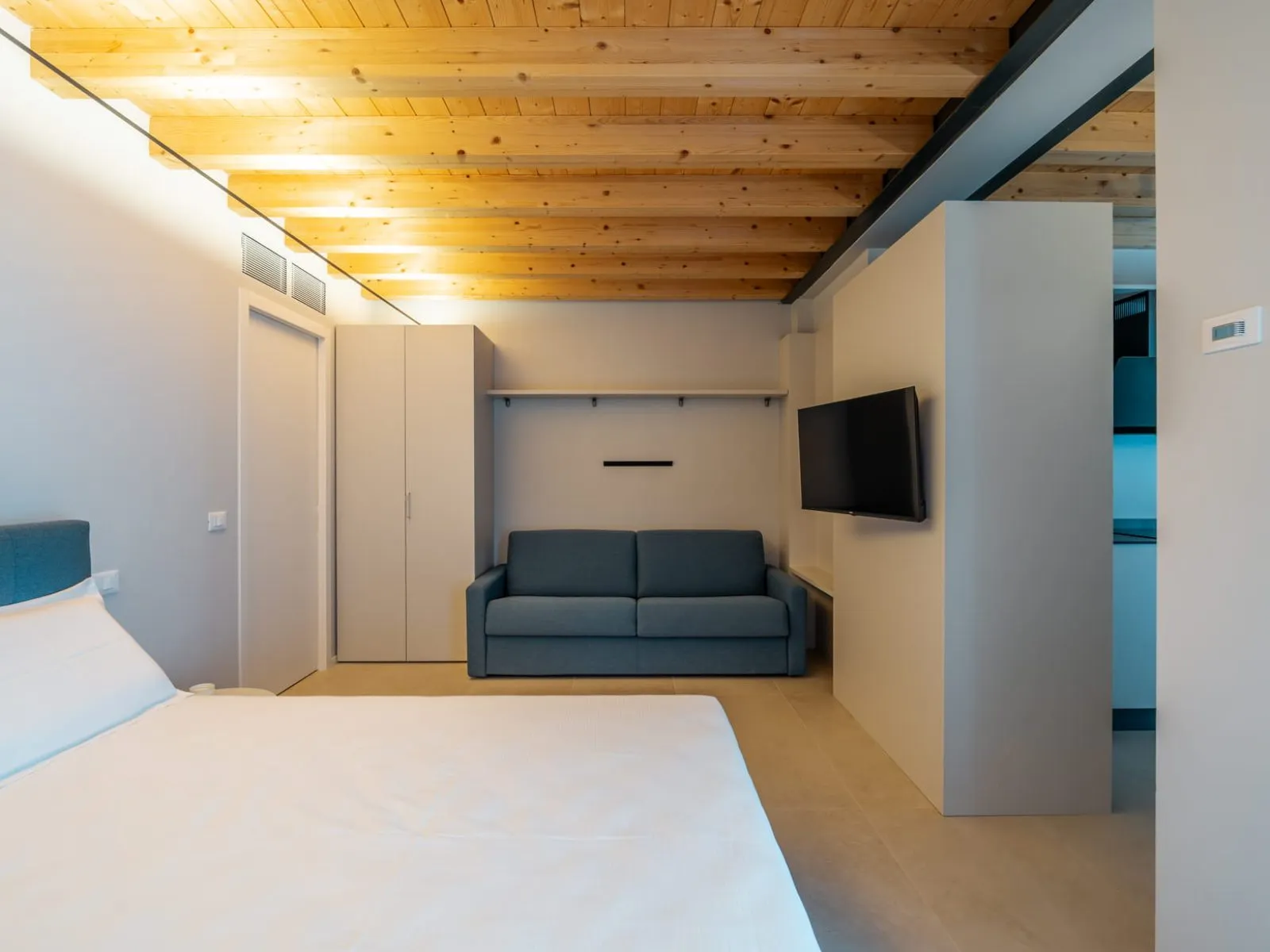 Bedroom with double bed and blue sofa bed, studio apartment S-09 Ca' Toni Treviso