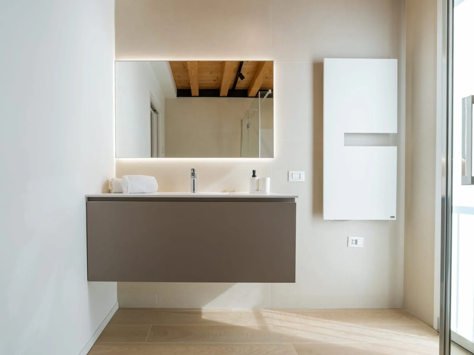 Dettaglio bagno con specchio retroilluminato e lavabo grigio monolocale S-10 Ca' Toni Treviso
