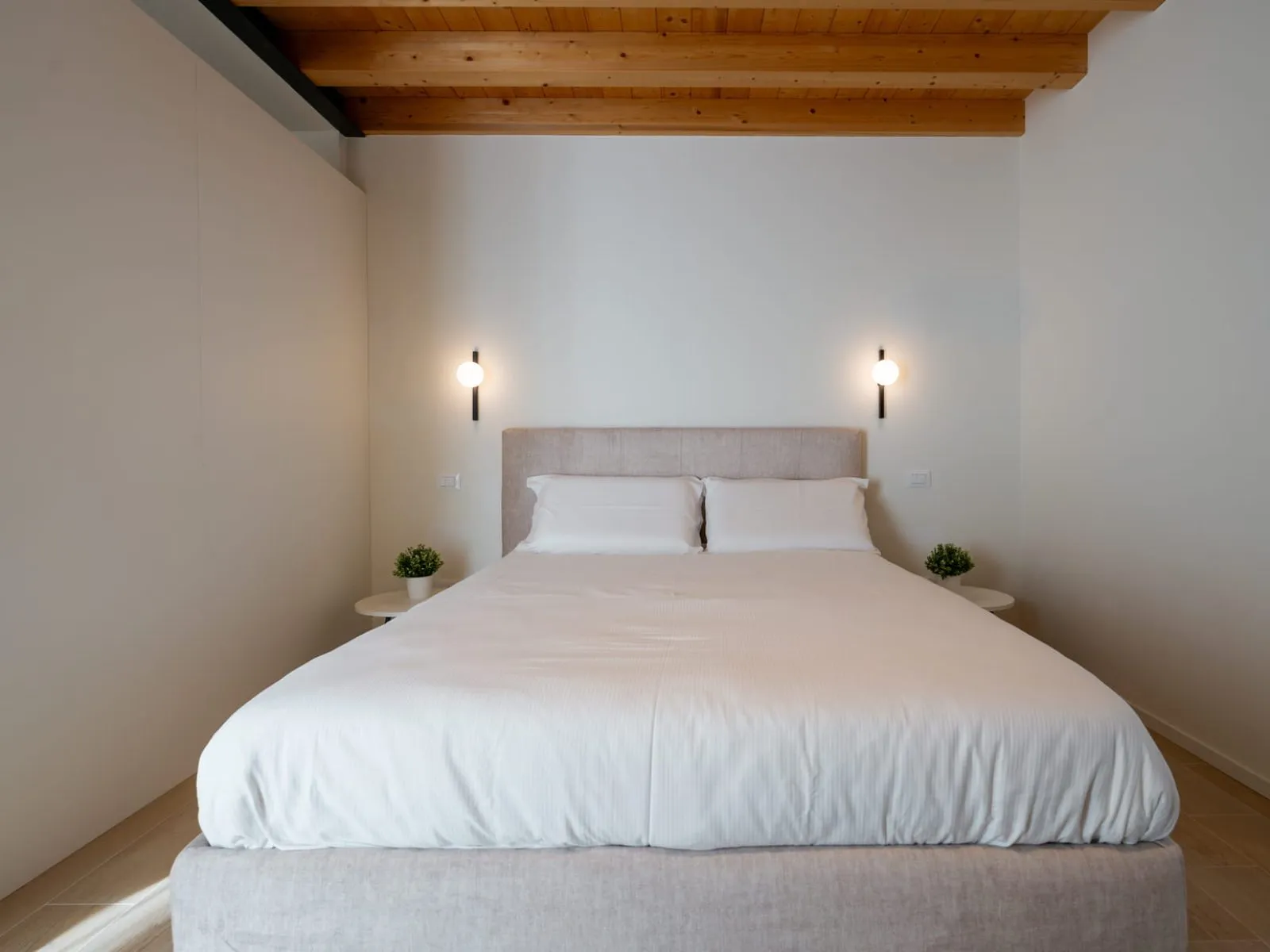 Camera da letto con testiera beige e soffitto in legno monolocale S-10 Ca' Toni Treviso