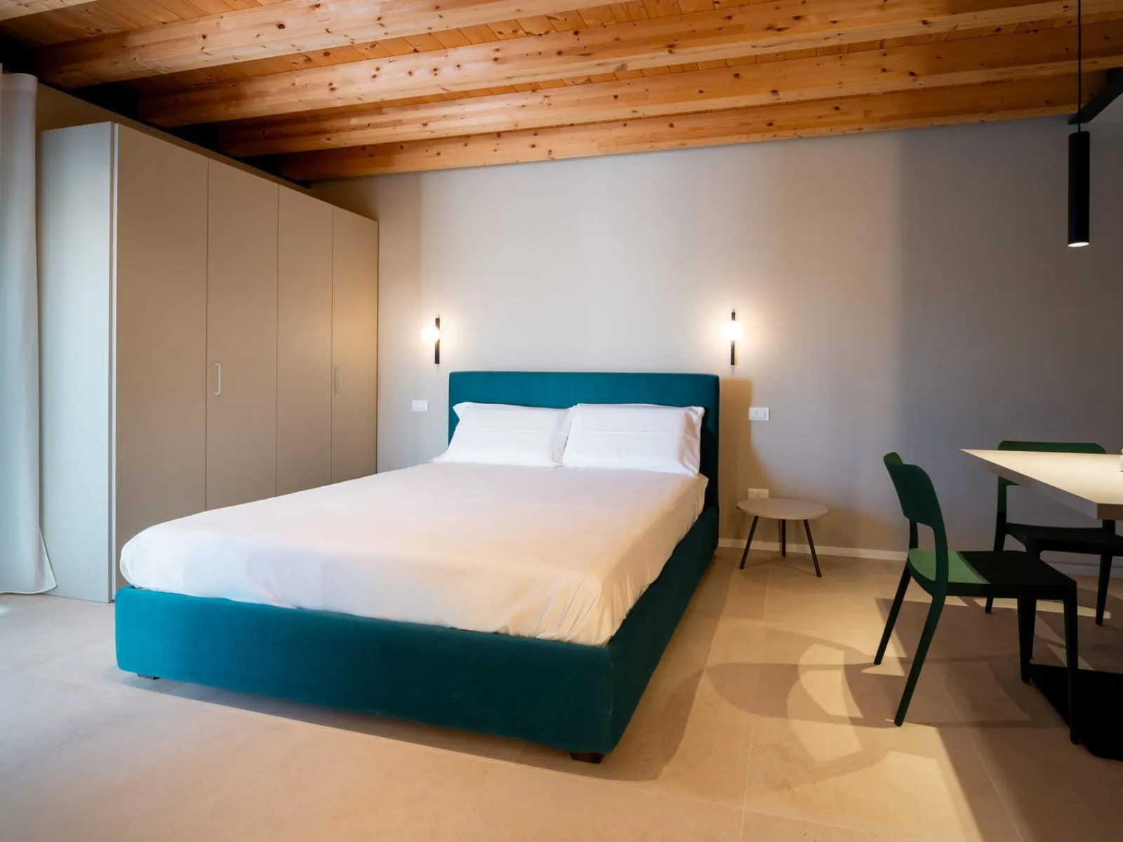 Camera da letto con testiera turchese e armadio a muro monolocale S-11 Ca' Toni Treviso
