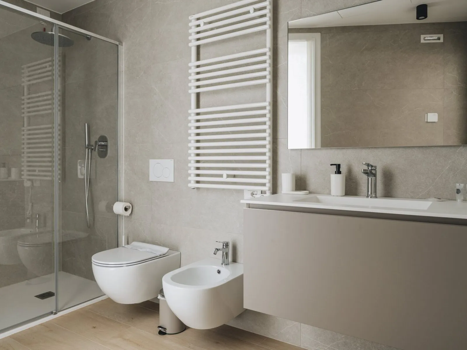 Bathroom with glass shower enclosure, wall-mounted fixtures, washbasin, mirror and heated towel rail – apartment T-04 Ca' Sette Treviso