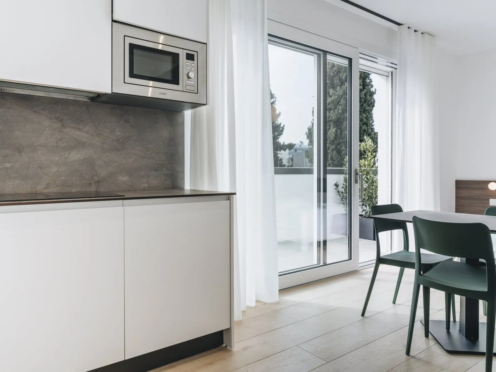 Equipped kitchen with integrated microwave and sliding door opening onto the private terrace – apartment T-06 Ca' Sette Treviso