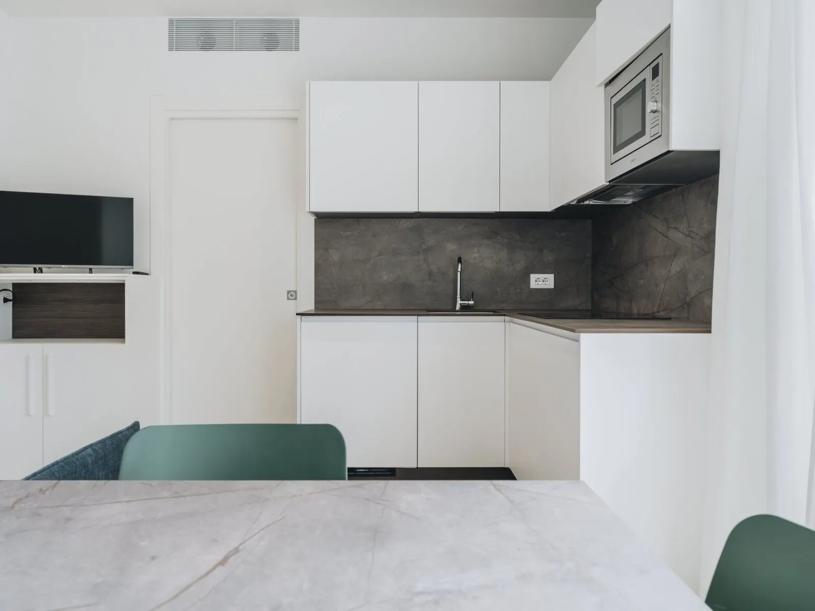 Equipped kitchen with integrated microwave and sliding door opening onto the private terrace – apartment T-06 Ca' Sette Treviso