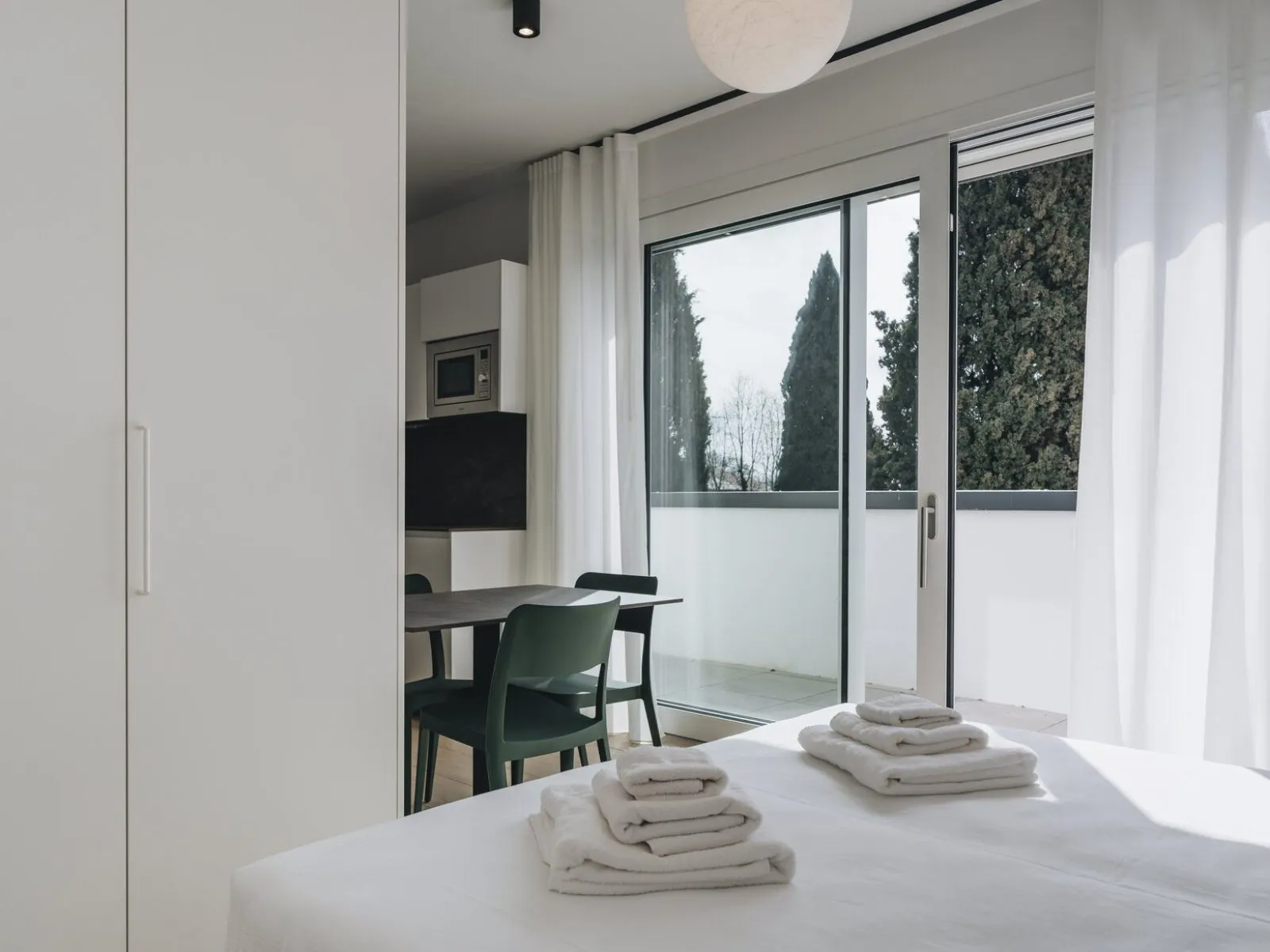 Bedroom with double bed, towels, built-in wardrobe and sliding door to the private terrace – apartment T-06 Ca' Sette Treviso