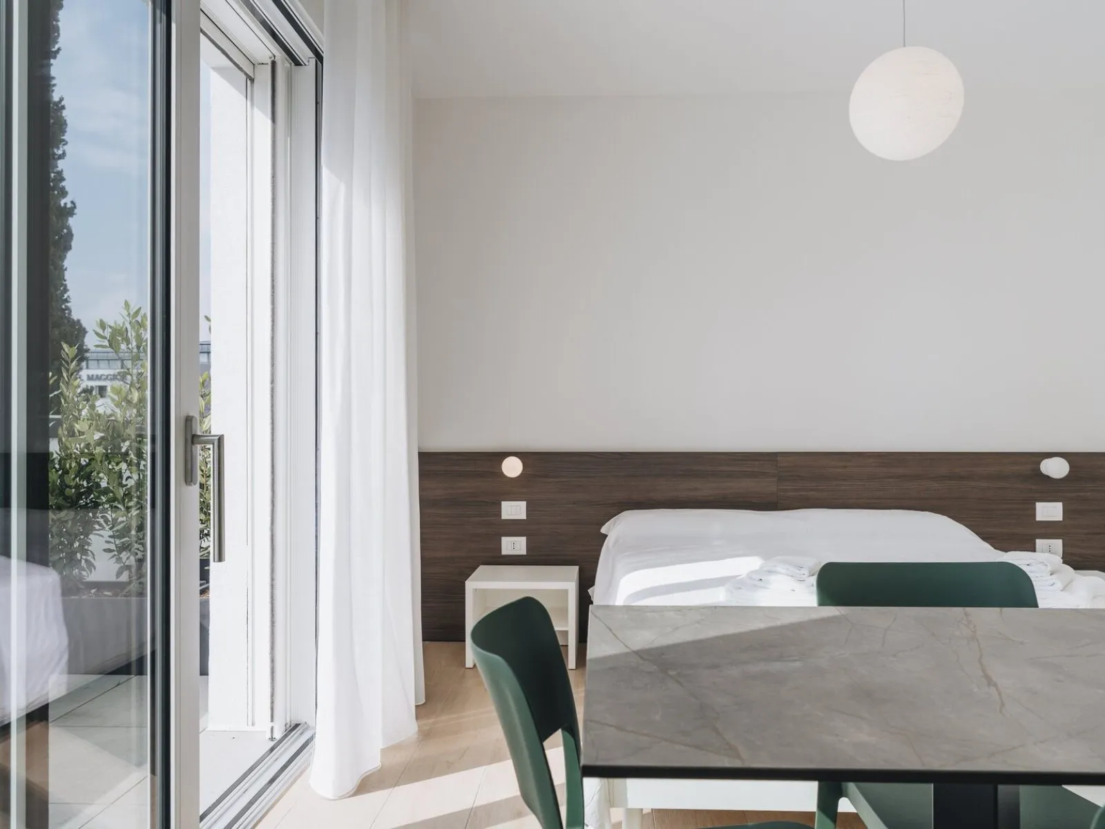 Bedroom with double bed, wood headboard and direct access to the private terrace – apartment T-06 Ca' Sette Treviso