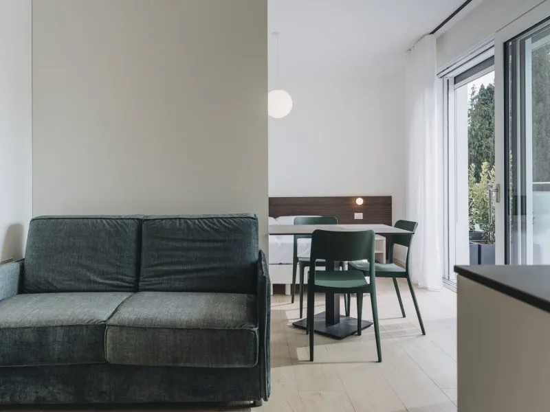 Living area with sofa, dining table, sleeping area and direct access to the private terrace – apartment T-07 Ca' Sette Treviso